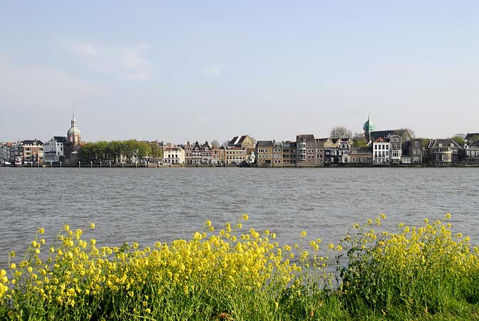 Het herenhuis, de kade en de rivierzijde met terassen boven de Oude Maas - met belendende panden aan de rivier.