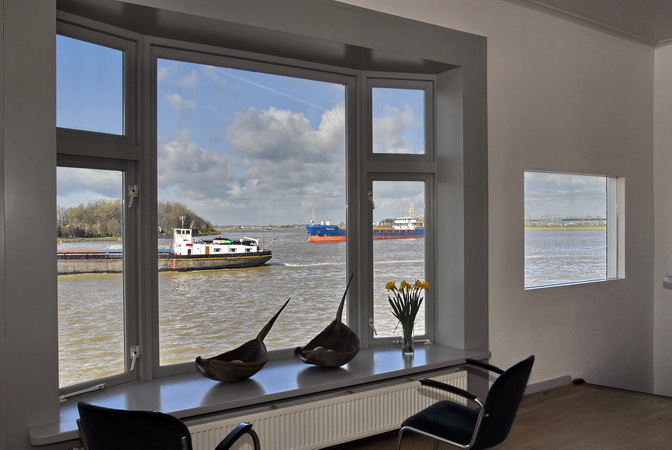 Het uitzicht op de rivier vanuit de studio van het grachtenpand aan de haven in Dordrecht.